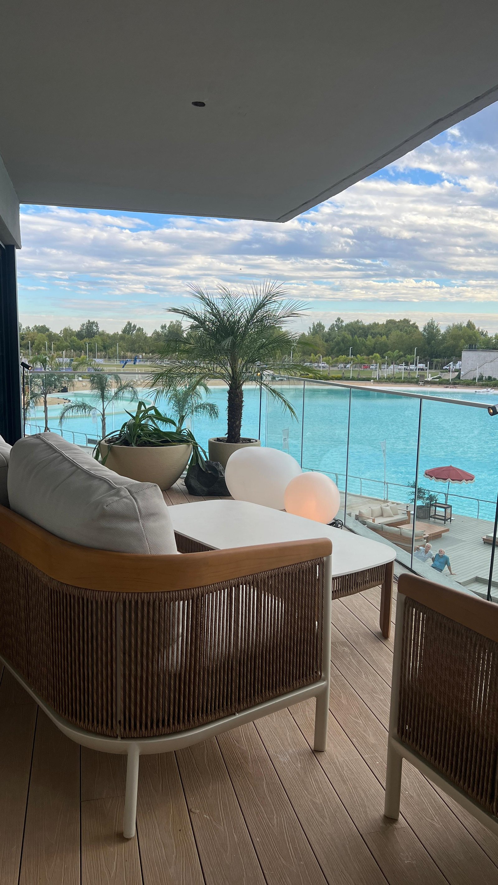Terraza moderna con vista a laguna artificial y muebles de rattan — proyecto EXPERIENCIA LIVING 26, por DESDE ASIA, en Cam. de los Remeros 1585